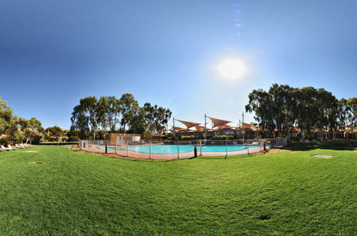 Virtual Tour of Uluru and Sails Resort. Deck chairs and green grass poolside at Sails Resort.