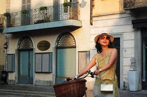 Woman on the streets of Como with the Hotel bicycle